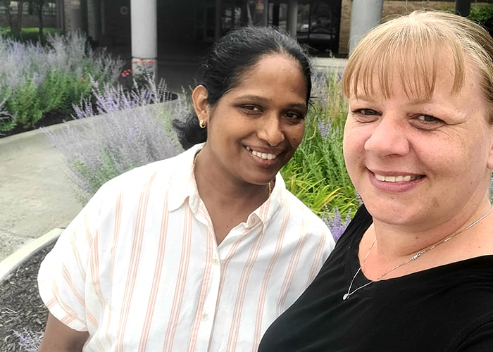 two females standing together smiling